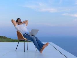 relaxed young man at home on balcony photo