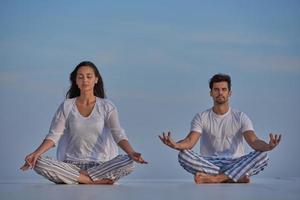 young couple practicing yoga photo