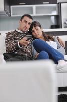 Relaxed young  couple watching tv at home photo