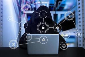 Hacker using computer with digital interface while sitting at desk of blurry interior. photo