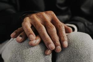 Close up of male wrinkled hands, old man is wearing vintage tone photo