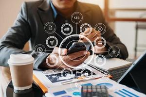 businessman working with mobile phone and tablet and laptop computer Internet of Things IOT technology with Augmented Reality on VR dashboard on desk in modern office photo