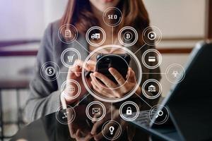 businesswoman or Designer using mobile phone with laptop and digital tablet laptop and document on desk in office with virtual icons network diagram i photo