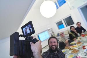 videografía profesional grabando video mientras la familia musulmana tiene iftar juntos durante el ramadán foto