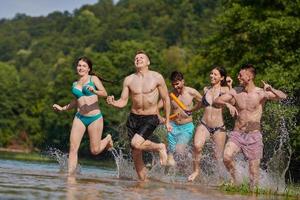 group of happy friends having fun on river photo