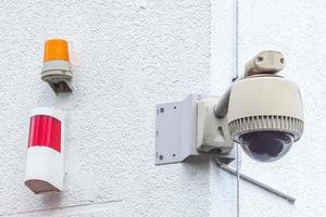 cámara de vigilancia con luz de advertencia en la pared de la casa
