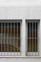 barred window on white house wall photo