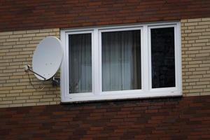 window in house wall with satellite antenna photo