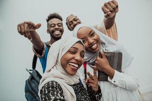 A group of multiethnic students take a selfie with a smartphone on a white background. Selective focus photo