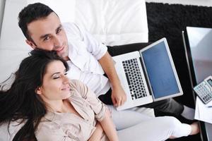 joyful couple relax and work on laptop computer at modern home photo