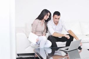 joyful couple relax and work on laptop computer at modern home photo