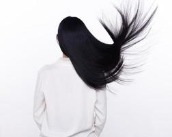 Black Straight Long Black Hair woman throw fly in air with fashion stylish and fun joy. Female turn back wear white shirt express emotion happy by blow wind hair, isolated white background photo