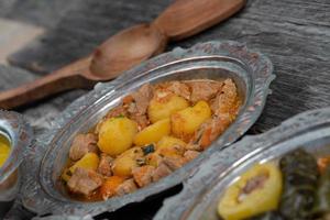 eid mubarak cena tradicional ramadán iftar. variada comida sabrosa en auténticos platos rústicos sobre fondo de mesa de madera. foto