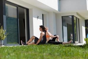 woman with personal trainer doing morning yoga exercises photo