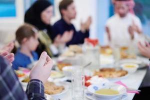 traditional muslim family praying before iftar dinner photo