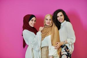 Young muslim women posing on pink background photo