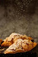 croissants recién horneados con almendras conjunto de deliciosos platos frescos en la mesa de madera. desayuno francés banner de espacio de copia de vista superior. foto