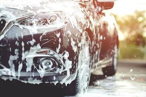 people man holding hand pink sponge for washing car. Concept car wash clean. photo