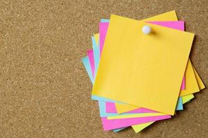 collection of colorful variety post it. paper note reminder sticky notes pin paper blue  on cork bulletin board. photo