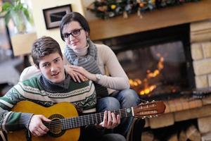 Young romantic couple relax on sofa in front of fireplace at home photo