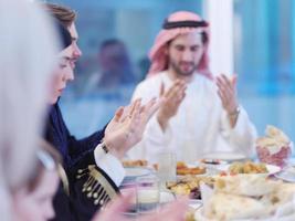 traditional muslim family praying before iftar dinner photo