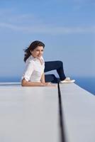 relaxed woman in front of luxury modern home photo