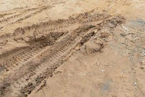 Tilt angle view of liquid mud off road and there are marks of tires. photo