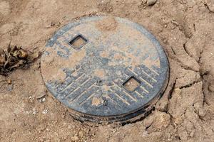 Plastic lid of the safety tank that emerges from the surface of the soil. Preparation for laying out the structure of the sewerage system. photo