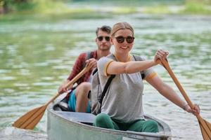 friends are canoeing in a wild river photo