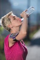 mujer bebiendo agua después de trotar foto