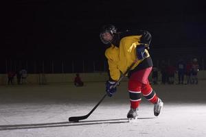 jugador adolescente de hockey sobre hielo en acción foto