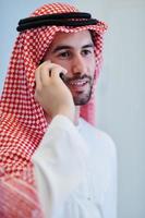 Portrait of young muslim businessman using mobile phone photo