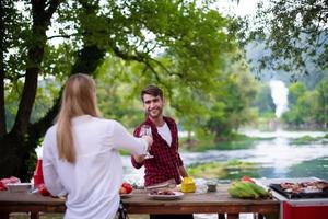 Una pareja feliz brindando con una copa de vino tinto durante una cena francesa al aire libre foto