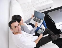 joyful couple relax and work on laptop computer at modern home photo