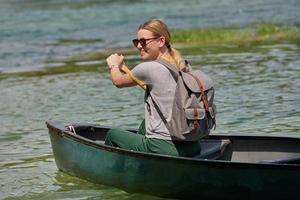 woman adventurous explorer are canoeing in a wild river photo