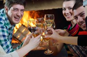 Young romantic couple sitting on sofa in front of fireplace at home photo