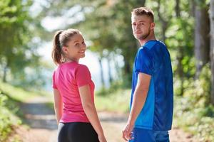 couple enjoying in a healthy lifestyle while jogging on a country road photo