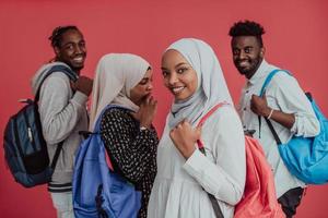 un grupo de estudiantes musulmanes africanos con mochilas posando sobre un fondo rosa. el concepto de educación escolar. foto