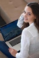 relaxed young woman at home working on laptop computer photo