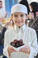 Arabian kid in the traditional clothes during iftar photo