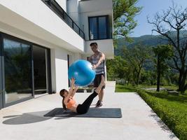 woman and personal trainer doing exercise with pilates ball photo