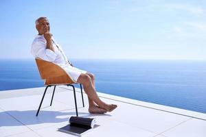 senior man in front of modern home photo