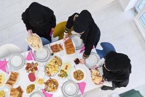 vista superior de mujeres musulmanas jóvenes preparando comida para iftar durante el ramadán foto