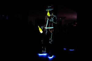 Professional barman and led light show. Silhouette of modern bartender shaking drink at night cocktail bar. photo