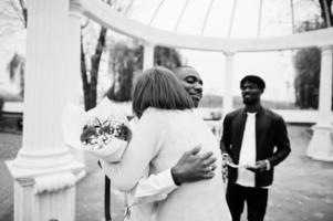 ceremonia de compromiso de boda con el pastor. feliz pareja multiétnica en la historia de amor. relaciones de hombre africano y mujer europea blanca. foto