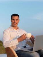 relaxed young man at home on balcony photo