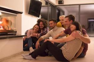 multiethnic couples sitting in front of fireplace photo