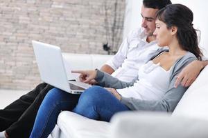 joyful couple relax and work on laptop computer at modern home photo
