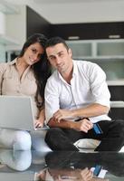 joyful couple relax and work on laptop computer at modern home photo