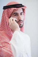young arabian businessman using smartphone at home photo